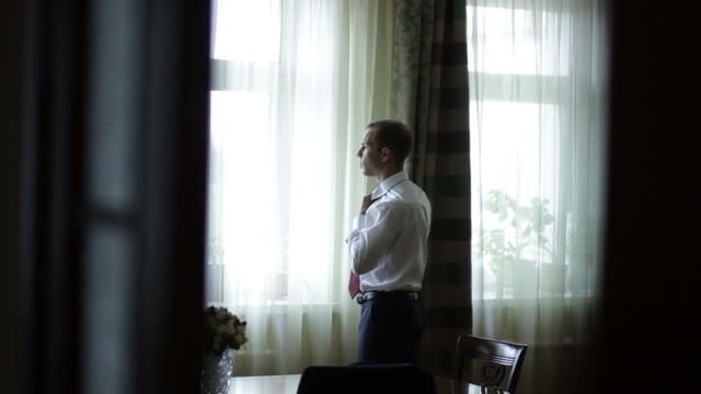 The Groom Adjusts His Collar.
