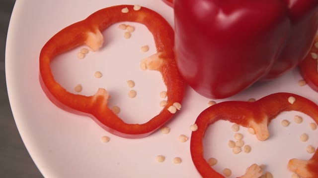 Red Bell Pepper Cut By Rings On A Plate Spinning.
