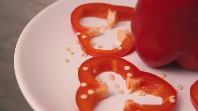 Red Bell Pepper Cut By Rings On A Plate Spinning.