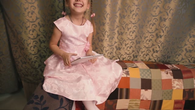 Little Girl Holding A Tablet And Very Cute Smile.