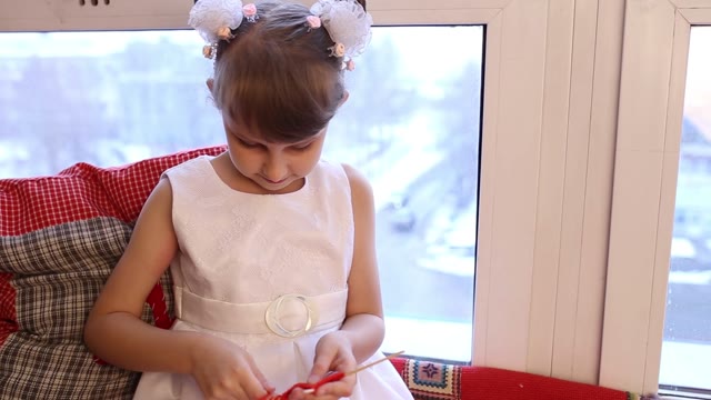 Girl Pulls A Red Yarn On A Stick.