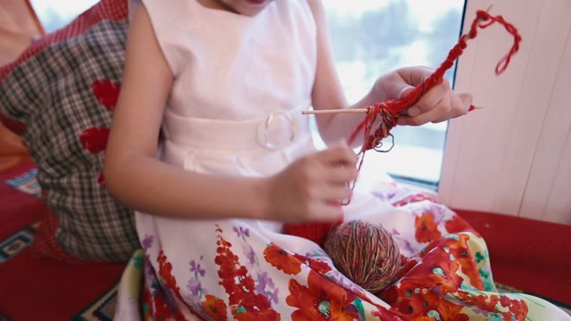 Girl Pulls A Red Yarn On A Wooden Stick.