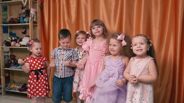 Young Children Standing In A Row, And Throw Up Candy.