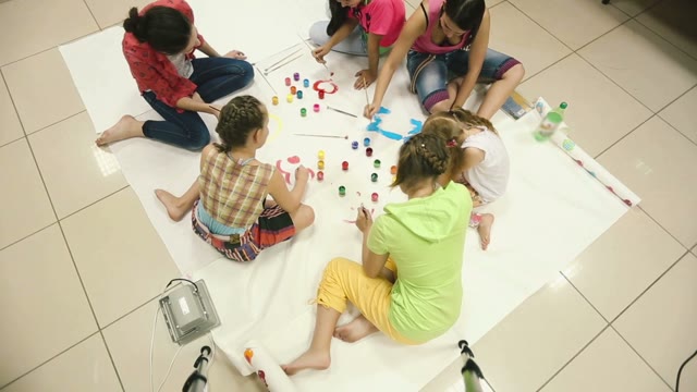 Little Girl Paint Colors On A Large Canvas On The Floor.