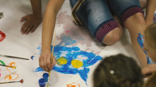 At The Foot Of Painted Fish. Children Paint On The Floor.