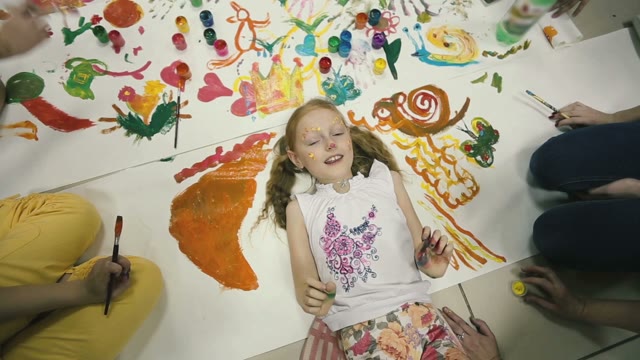 Girl Lying On The Floor Around Her Picture. She Painted Face.