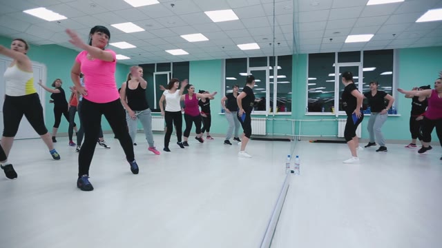 Girls In The Gym In Front Of The Mirror Doing Fitness.