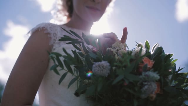 The Bride Standing With Bouquet Of Flowers.
