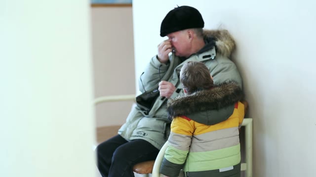 Grandfather Sitting In A Room And Talking With His Grandson.