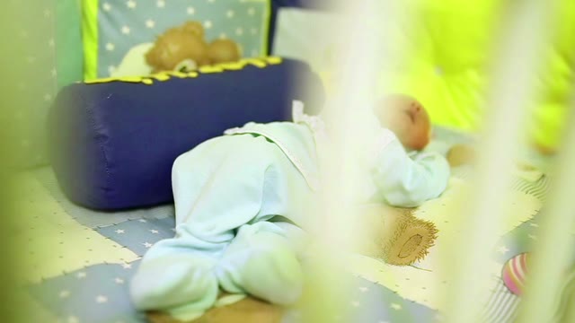 A Newborn Sleeps In A Crib. Close-up.