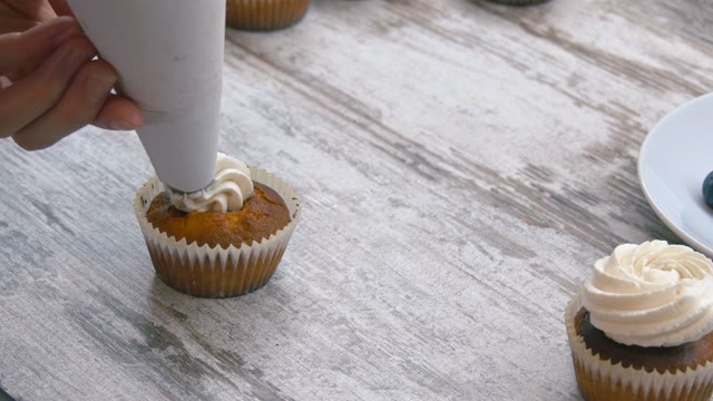 Cooking Cupcakes. Apply Cream. Close-up.