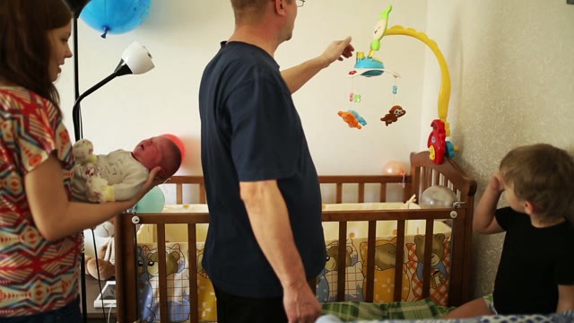 Family In The Children's Room, Next To The Crib.