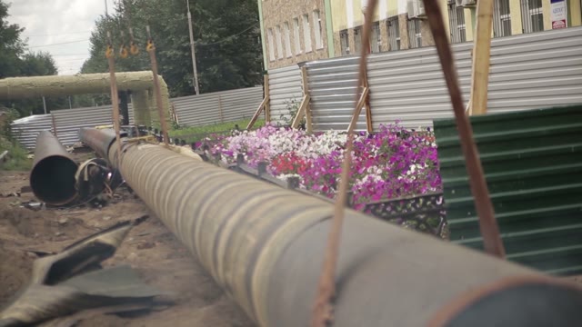Work With Welding Works. Near A Flower Bed. Repair Pipes.