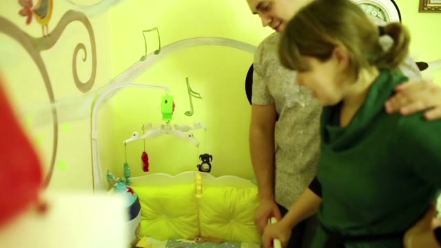 Happy Parents Look At The Sleeping Baby
