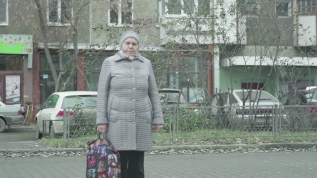 A Woman Standing At The Bus Stop