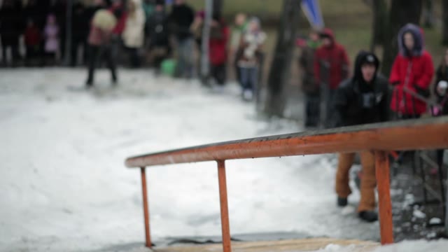 Slides On The Rail On A Snowboard. Competition