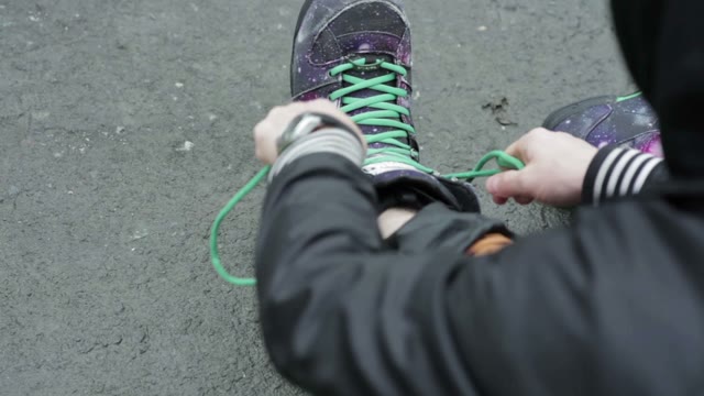 Man Tying Shoelaces On Special Snowboard Boots. Close-up