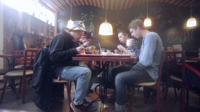 Young People Eating In A Cozy Cafe