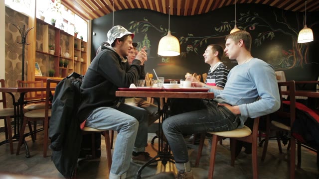 Young People Eating And Talking In A Cafe