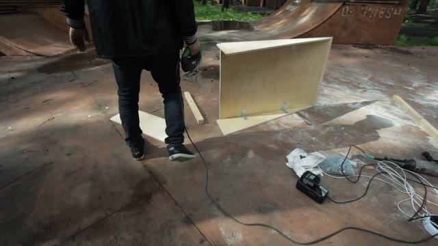 The Guy Working Electric Jigsaw. Skate Park. Around The Tall Trees
