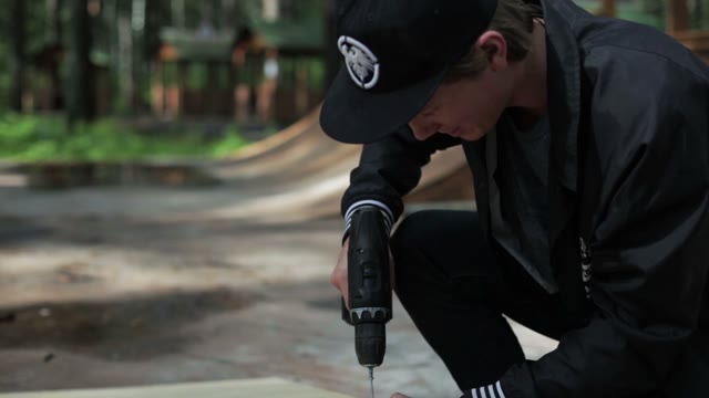 Young Man Twists The Screw. Close-up