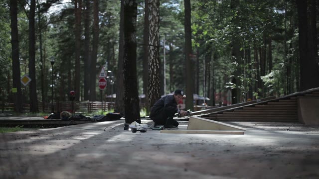 Young Man Polishing A Wooden Springboard. View Through The Rabitz