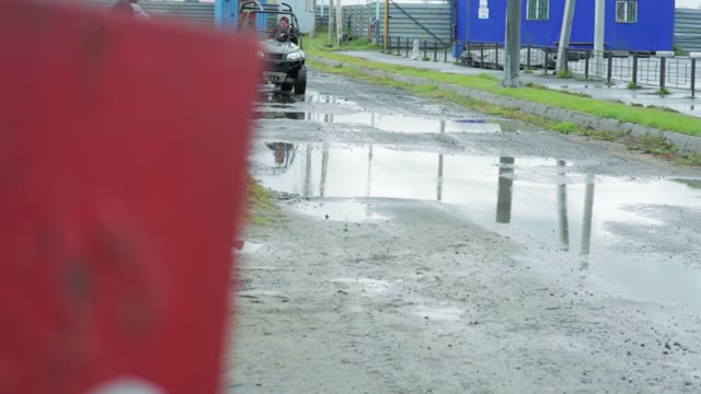 A Man Riding A Quad Bike Through The Puddles