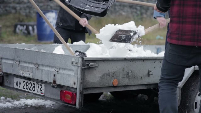 Young People Are Throwing The Snow Out Of The Trailer