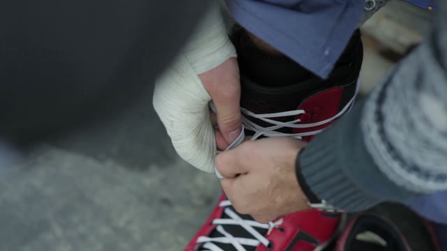 Snowboarder Tying Shoelaces. Close-up
