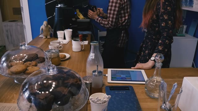 Barista Shows How To Operate The Coffee Machine. Nearby Stands A Woman. Slow