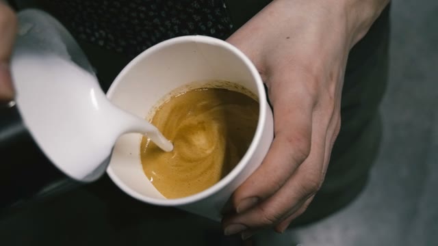 The Cream Is Added To The Coffee. Close-up. Slow Motion