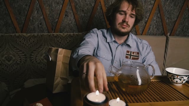 Young Man Covering Teapot Lid. Slow Motion. Close-up