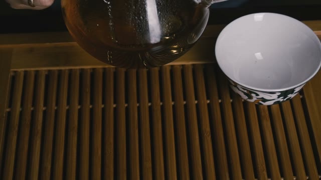 Pour The Tea Into A Cup. Close-up. Slow Motion