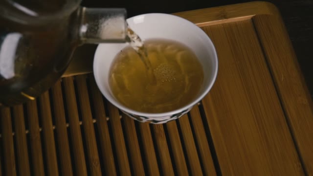Pour Tea From Teapot Into A Cup. Close-up. Slow Motion