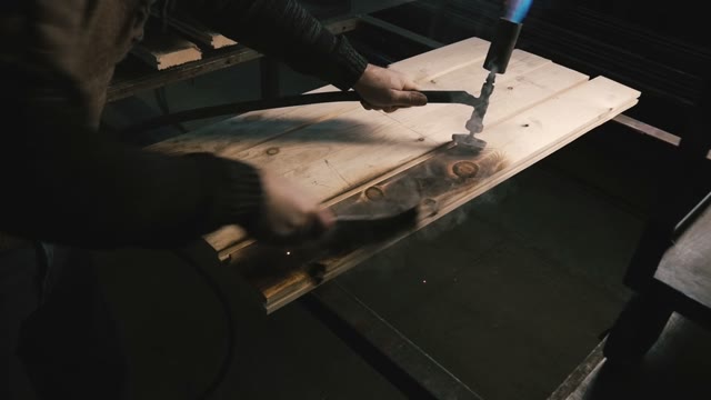 Carpenter Grinds Burning Wood. Close-up
