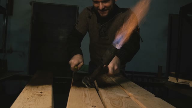 Joiner Grinds Burnt Wood In The Workshop. Close-up