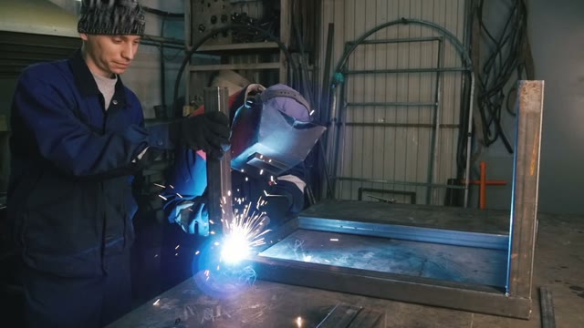 Two Men Are Working With Welding Apparatus. Close-up