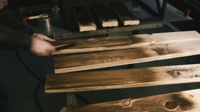 Carpenter Cleans Burned Board. Close-up