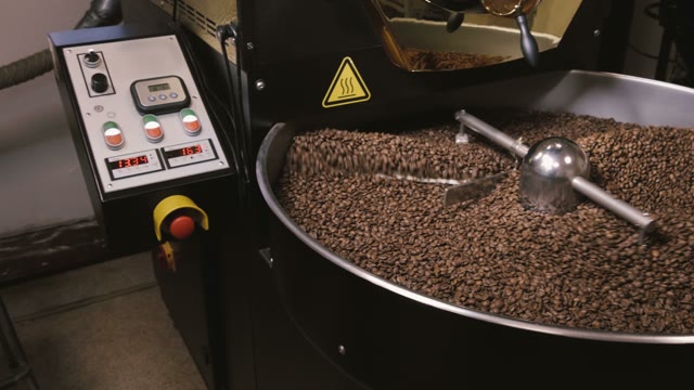 Factory Coffee Roasting Machine In Operation, Turning And Stirring Roasted Beans