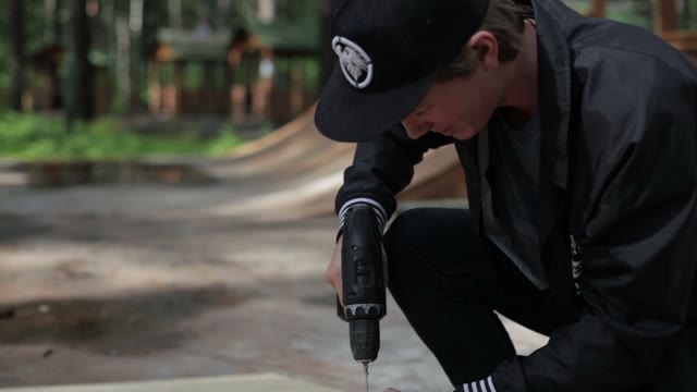 Man Drill A Nail Goods From Wood In The Skatepark