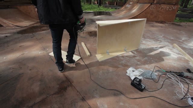 Man Sawing Wood Products In Skatepark