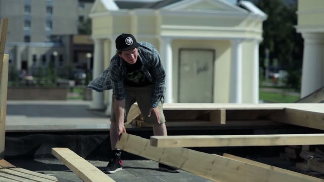 Man Moves Pieces Of Wood On The Outdoor
