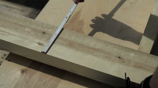 Man Measuring A Wooden Block