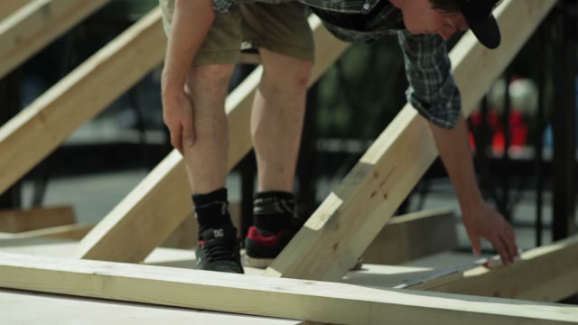 Man Measuring A Wooden Structure