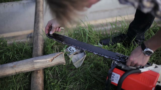 Man Pulls A Chain On A Chainsaw