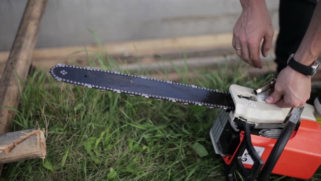 Man To Tighten The Screws On The Chainsaw