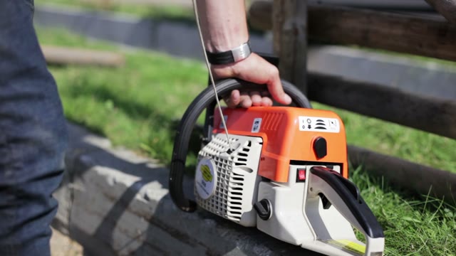 Man Starts Chainsaw On The Outdoor