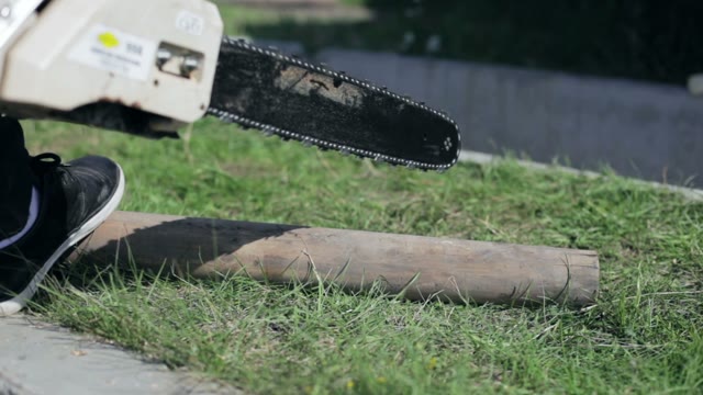 Man Saws Off Of The Timber Chainsaw Close-up