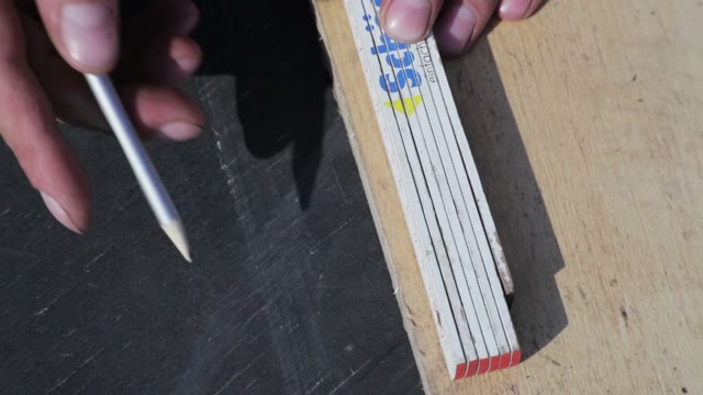 Man Draws A Markup On A Wooden Board Close-up