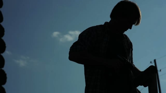 Silhouette Of A Man Drills A Wood